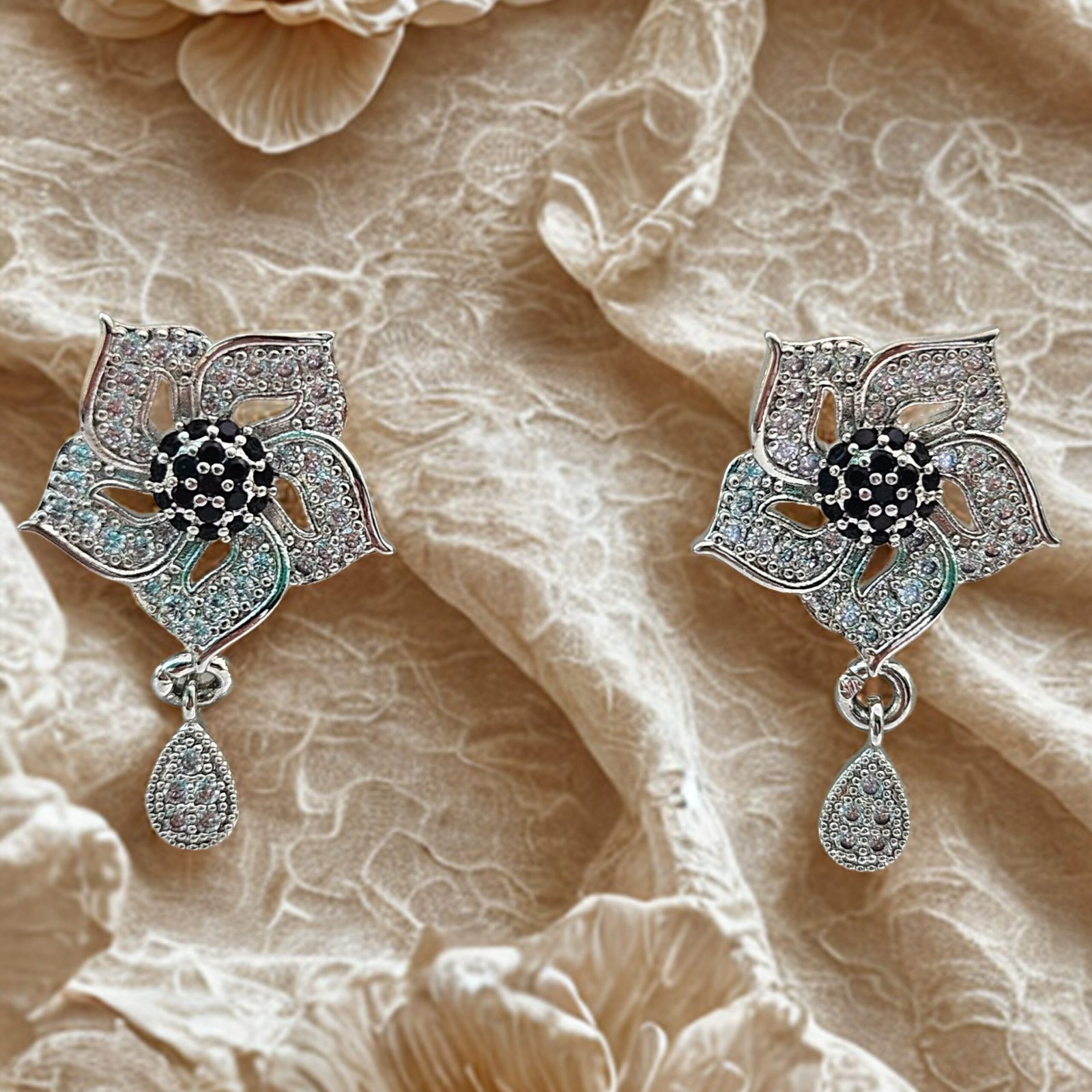 silver-toned, flower-shaped earrings with black and white accent stones - Image 3