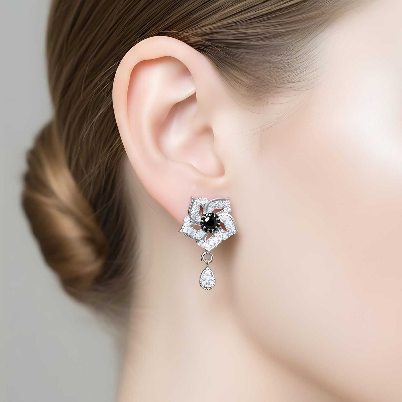 silver-toned, flower-shaped earrings with black and white accent stones - Image 4